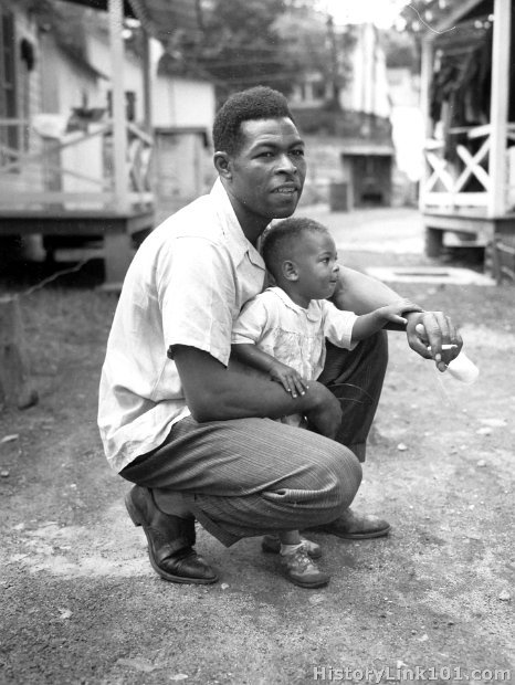 Gonzalla Sulliven, miner, with his little boy