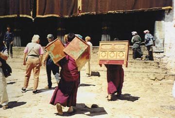 monks from tibet carry boxes